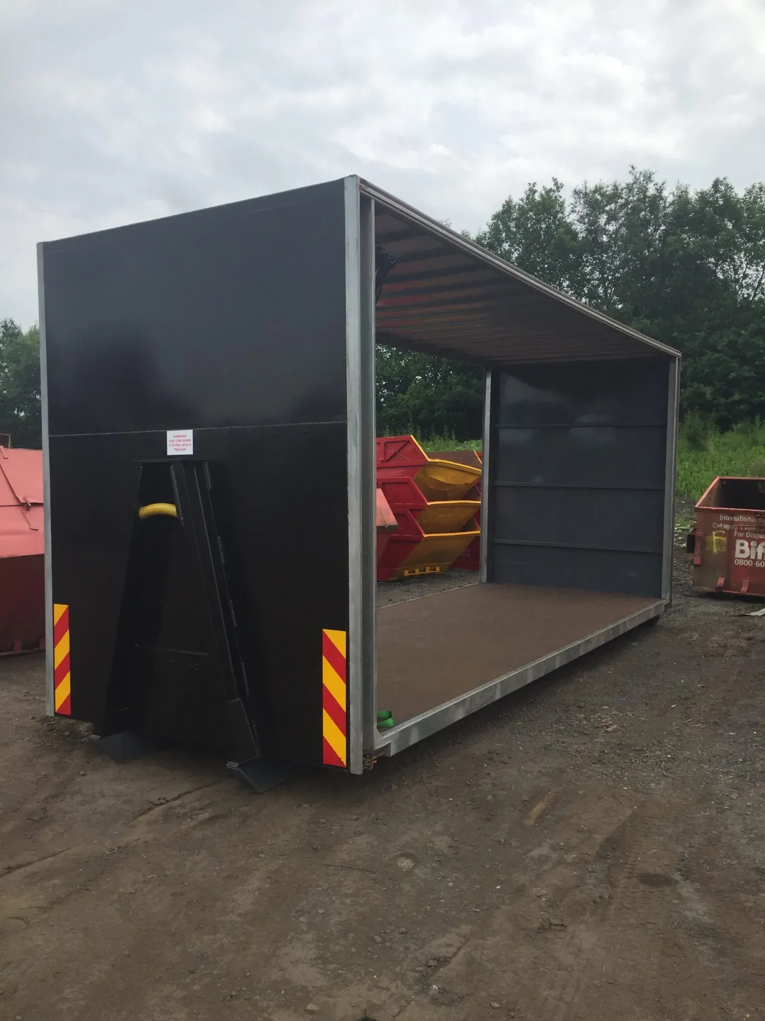 A large container finished in black with high-visibility chevrons, ready for the customer