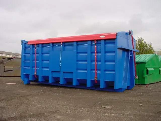 A blue roll-on roll-off container with a red sheeting system fitted