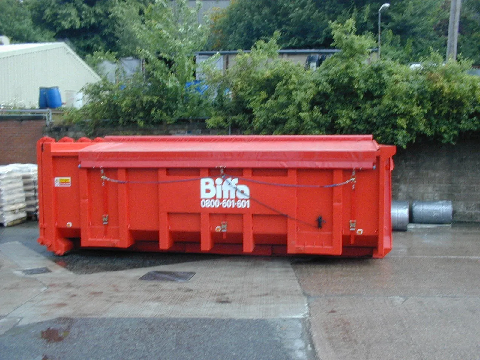 A red roll-on roll-off container fitted with a sheeting system