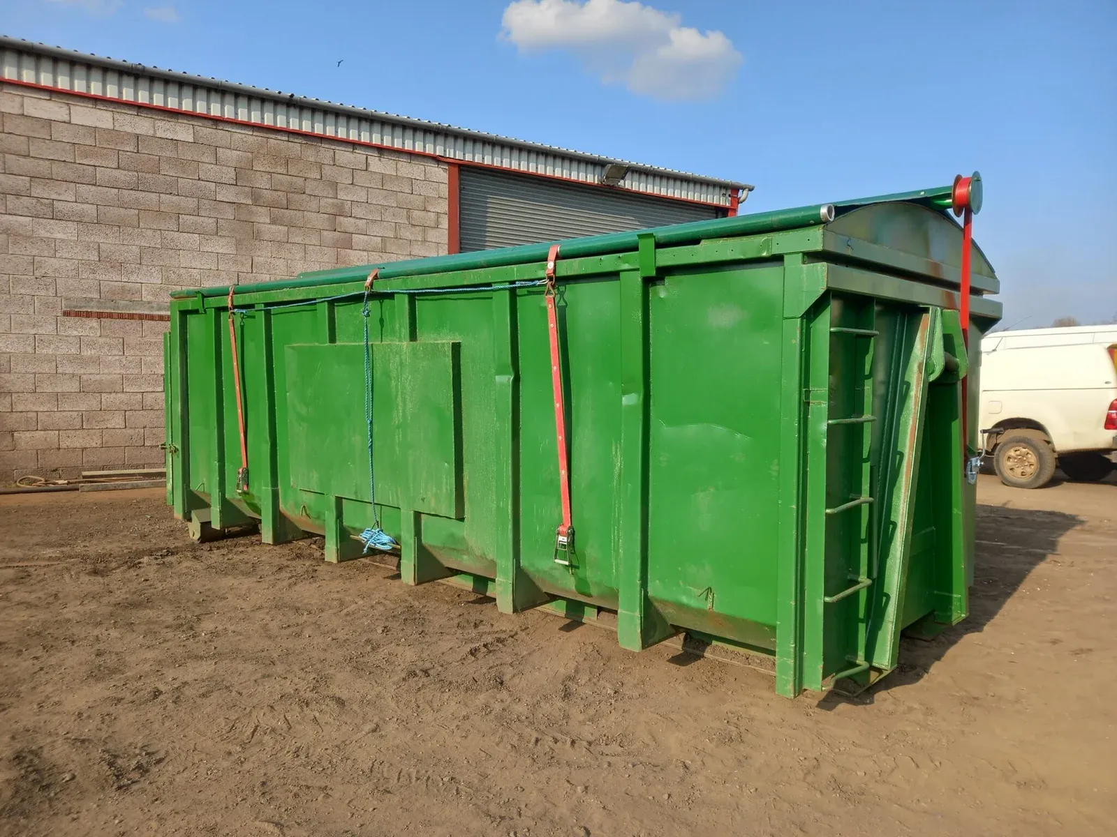 A green roll-on roll-off container waiting for a new sheeting system to be fitted