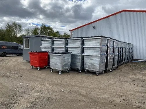 A yard of wheelie bins, some finished and some still unpainted