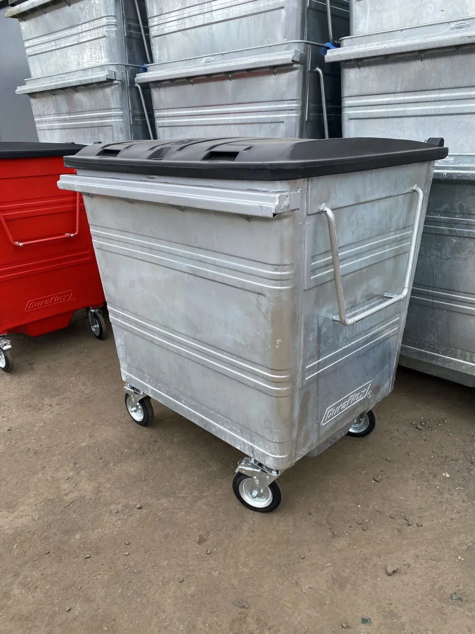 A galvanised four-wheeled commercial wheelie bin